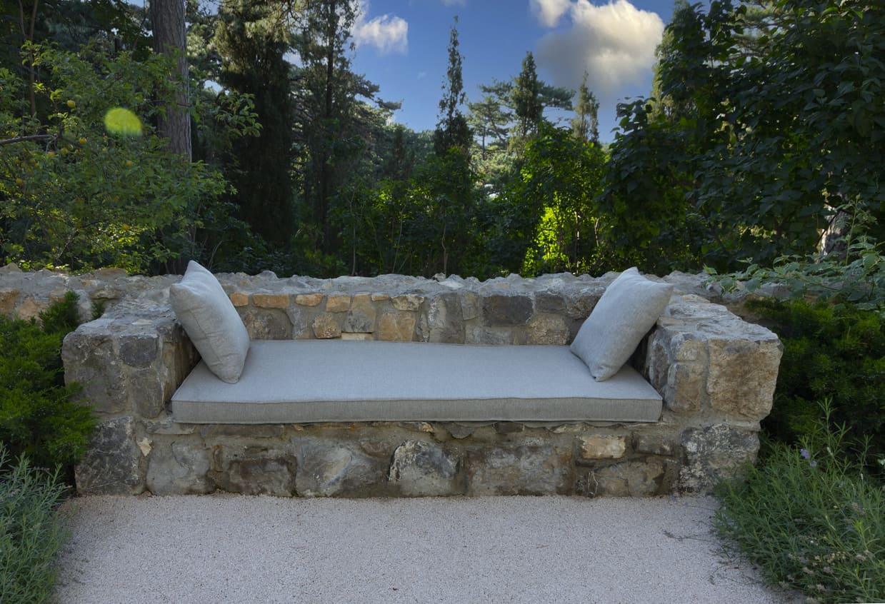 Bench with soft pillows in a garden.